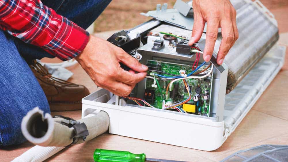 Technician repairing air conditioner electronics