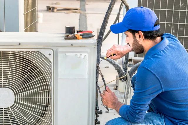 Technician repairing outdoor air conditioning unit